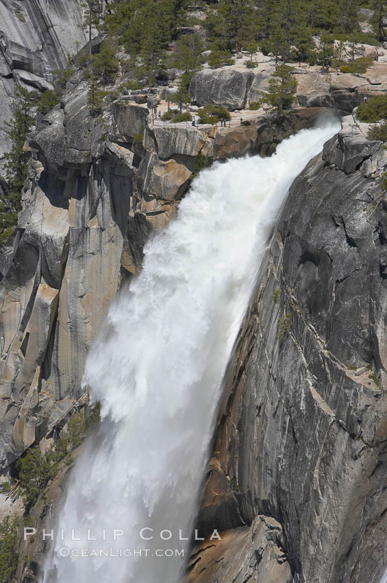 The brink of Nevada Falls, with hikers visible at the precipice. Nevada Falls marks where the Merced River plummets almost 600 through a joint in the Little Yosemite Valley, shooting out from a sheer granite cliff and then down to a boulder pile far below. Yosemite National Park, California, USA, natural history stock photograph, photo id 16120