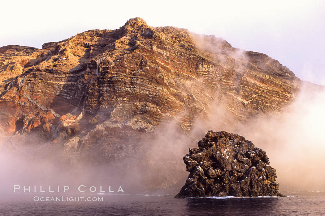 Pilot Rock (Roca Pilote), a undersea spire which extends 100 out of the water, stands below the immense seacliffs and morning clouds at the north end of Guadalupe Island (Isla Guadalupe), far offshore of the Baja California peninsula. Mexico, natural history stock photograph, photo id 09750