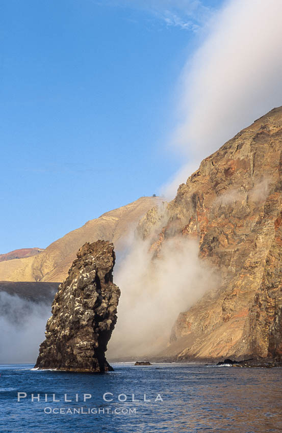 Pilot Rock (Roca Pilote), a undersea spire which extends 100 out of the water, stands below the immense seacliffs and morning clouds at the north end of Guadalupe Island (Isla Guadalupe), far offshore of the Baja California peninsula. Mexico, natural history stock photograph, photo id 09749