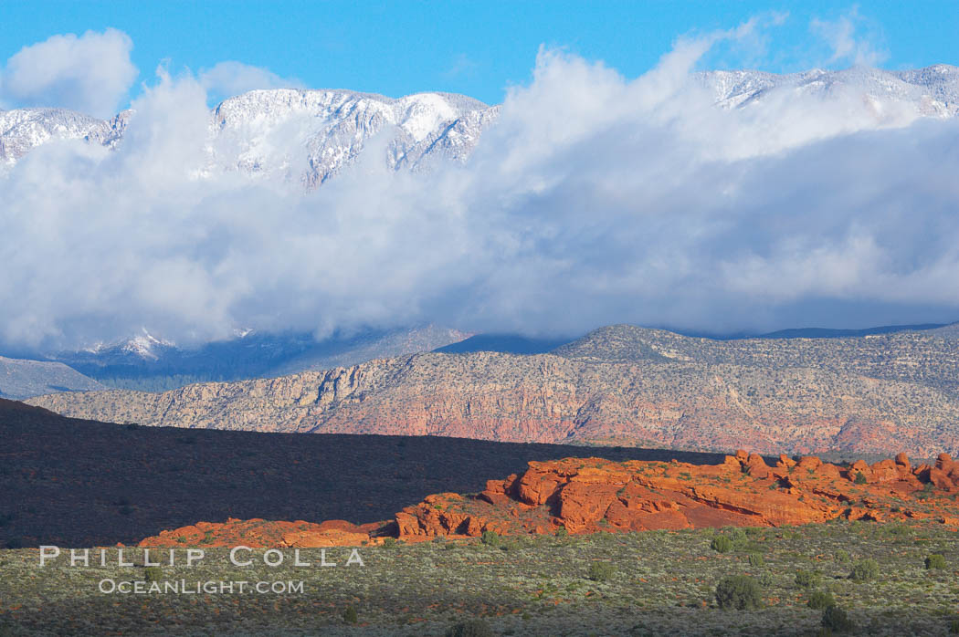Red sandstone hills, clouds and snow covered mountains. Hurricane, Utah, USA, natural history stock photograph, photo id 12527