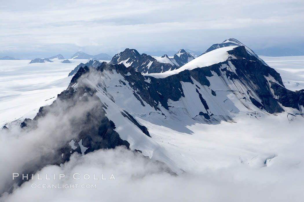 The Kenai Mountains rise above thick ice sheets and the Harding Icefield which is one of the largest icefields in Alaska and gives rise to over 30 glaciers. Kenai Fjords National Park, USA, natural history stock photograph, photo id 19022