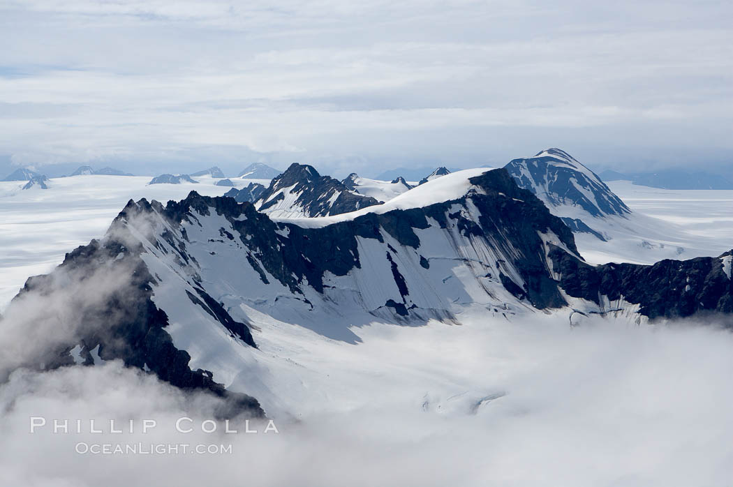 The Kenai Mountains rise above thick ice sheets and the Harding Icefield which is one of the largest icefields in Alaska and gives rise to over 30 glaciers. Kenai Fjords National Park, USA, natural history stock photograph, photo id 19044