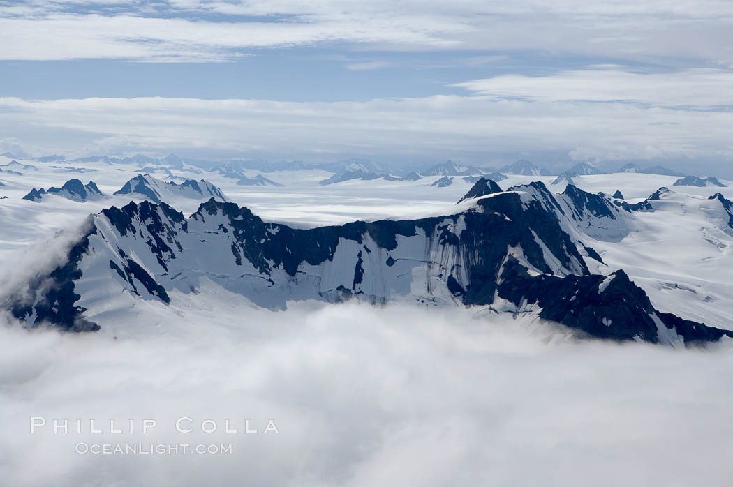 The Kenai Mountains rise above thick ice sheets and the Harding Icefield which is one of the largest icefields in Alaska and gives rise to over 30 glaciers. Kenai Fjords National Park, USA, natural history stock photograph, photo id 19043