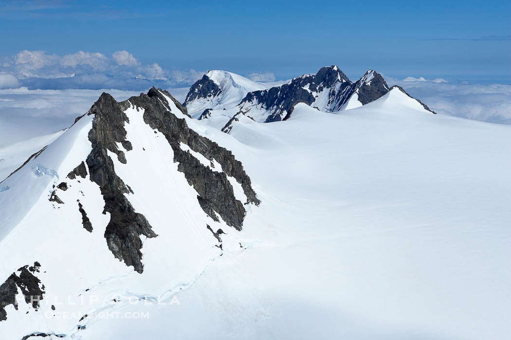 The Kenai Mountains rise above thick ice sheets and the Harding Icefield which is one of the largest icefields in Alaska and gives rise to over 30 glaciers., natural history stock photograph, photo id 19025