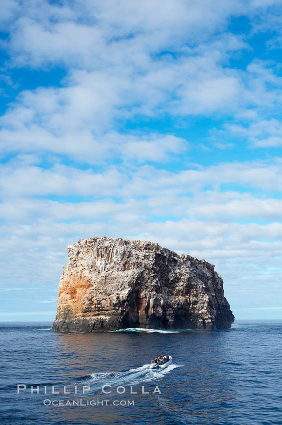 An inflatable boat full of adventurous divers heads towards Roca Redonda (round rock), a lonely island formed from volcanic forces, in the western part of the Galapagos archipelago. Galapagos Islands, Ecuador, natural history stock photograph, photo id 16644