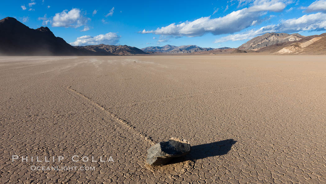 Sailing stone on the Racetrack Playa. The sliding rocks, or sailing stones, move across the mud flats of the Racetrack Playa, leaving trails behind in the mud. The explanation for their movement is not known with certainty, but many believe wind pushes the rocks over wet and perhaps icy mud in winter. Death Valley National Park, California, USA, natural history stock photograph, photo id 27688