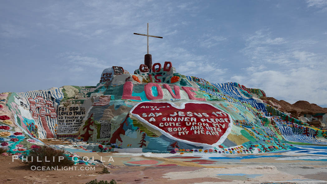 Salvation Mountain, near the desert community of Slab City and the small town of Niland on the east side of the Salton Sea.  Built over several decades by full-time resident Leonard Knight, who lives at the site, Salvation Mountain was built from over 100,000 gallons of paint, haybales, wood and metal and was created by Mr. Knight to convey the message that "God Loves Everyone". California, USA, natural history stock photograph, photo id 22516