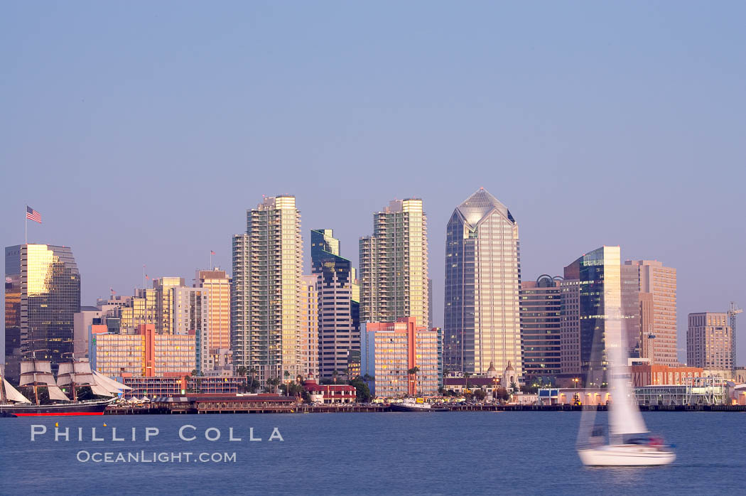 San Diego city skyline at dusk, viewed from Harbor Island, a sailboat cruises by in the foreground, the Star of India at left. California, USA, natural history stock photograph, photo id 14535