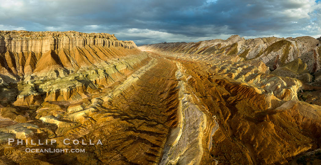 Aerial photo of the San Rafael Reef at dawn. This is a canyon-like section of the San Rafael Reef, photographed at sunrise. The "reef proper" is on the right, with its characteristic triangular flatiron erosion. The canyon in the center is a fold in the Earth's crust affiliated with the boundary of the San Rafael Swell.  The colors seen here arise primarily from Navajo and Wingate sandstone. Utah, USA, natural history stock photograph, photo id 39786