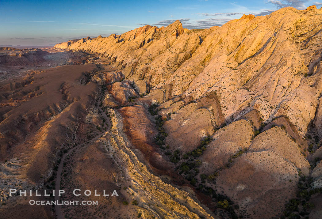 Aerial photo of the San Rafael Reef at dawn.  A fold in the Earth's crust leads to this inclined section of the San Rafael Reef, at the eastern edge of the San Rafael Swell.  Clearly seen are the characteristic triangular flatiron erosion patterns that typical this formation. The colors seen here arise primarily from Navajo and Wingate sandstone. Utah, USA, natural history stock photograph, photo id 39784