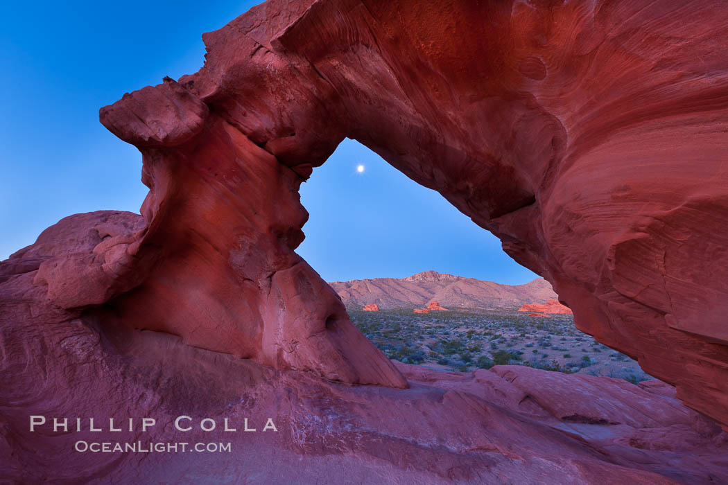 Natural arch formed in sandstone frames the setting moon. Valley of Fire State Park, Nevada, USA, natural history stock photograph, photo id 26502