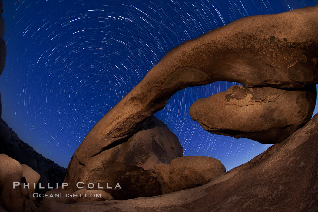 Star trails and Arch Rock. Polaris, the North Star, is at the center of the circular arc star trails as they pass above this natural stone archway in Joshua Tree National Park. Alabama Hills Recreational Area, California, USA, natural history stock photograph, photo id 27709