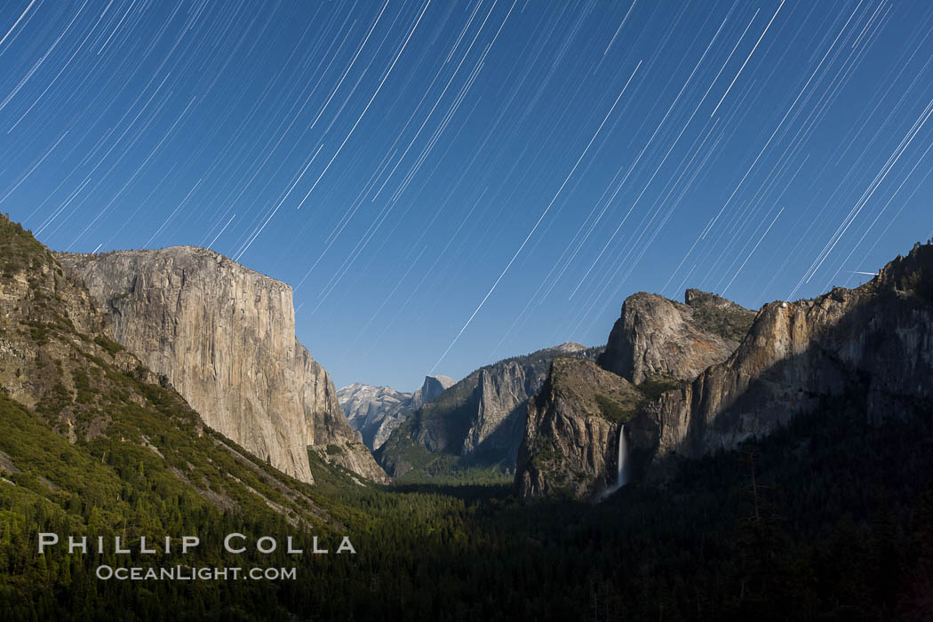 Star trails over Yosemite Valley, viewed from Tunnel View, the floor of Yosemite Valley illuminated by a full moon.  El Capitan on left, Bridalveil Falls on right, Half Dome in distant center. Yosemite National Park, California, USA, natural history stock photograph, photo id 27736