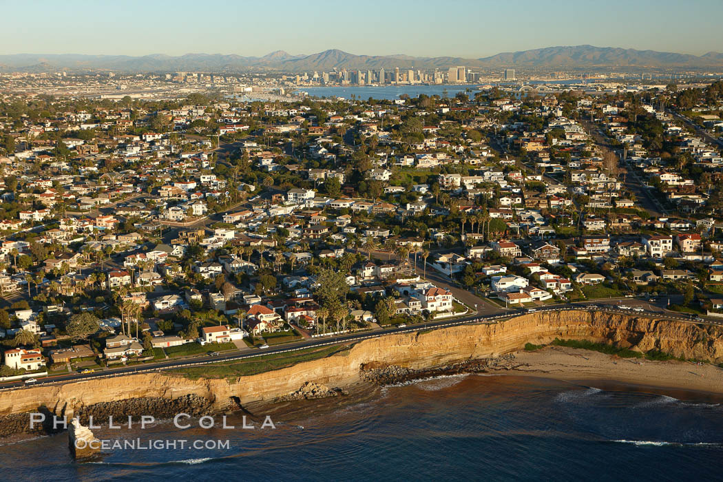 Sunset Cliffs, a coastal community of San Diego, boasts beautiful homes and rugged, scalloped bluffs rising above the Pacific Ocean.  Downtown San Diego can be seen in the distance. California, USA, natural history stock photograph, photo id 22325