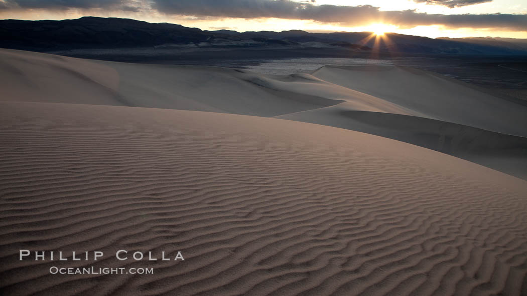 Sunset on the Eureka Dunes.  The Eureka Valley Sand Dunes are California's tallest sand dunes, and one of the tallest in the United States.  Rising 680' above the floor of the Eureka Valley, the Eureka sand dunes are home to several endangered species, as well as "singing sand" that makes strange sounds when it shifts.  Located in the remote northern portion of Death Valley National Park, the Eureka Dunes see very few visitors. USA, natural history stock photograph, photo id 25240