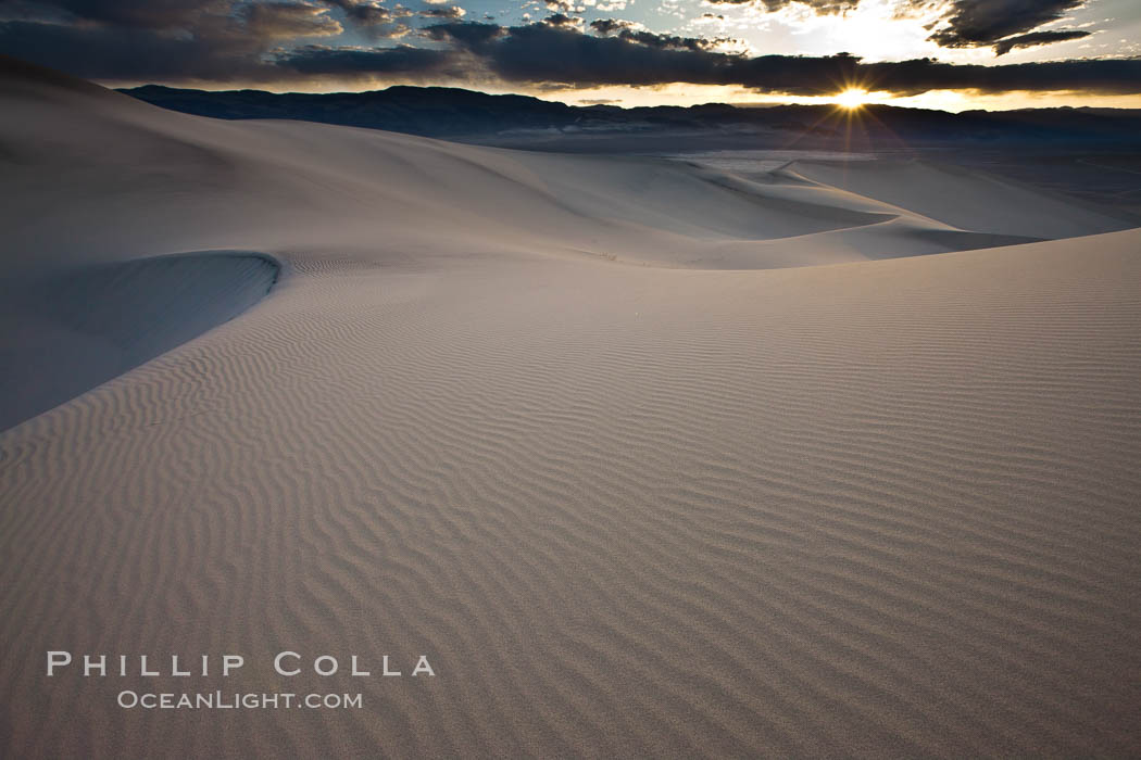 Sunset on the Eureka Dunes.  The Eureka Valley Sand Dunes are California's tallest sand dunes, and one of the tallest in the United States.  Rising 680' above the floor of the Eureka Valley, the Eureka sand dunes are home to several endangered species, as well as "singing sand" that makes strange sounds when it shifts.  Located in the remote northern portion of Death Valley National Park, the Eureka Dunes see very few visitors. USA, natural history stock photograph, photo id 25356