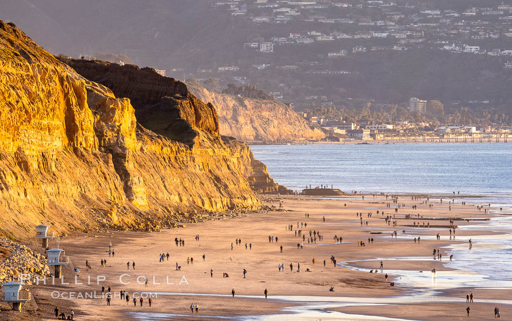 Torrey Pines State Beach on the extreme low King Tide, people walking on the beach, sunset light and La Jolla in the distance, Torrey Pines State Reserve, San Diego, California