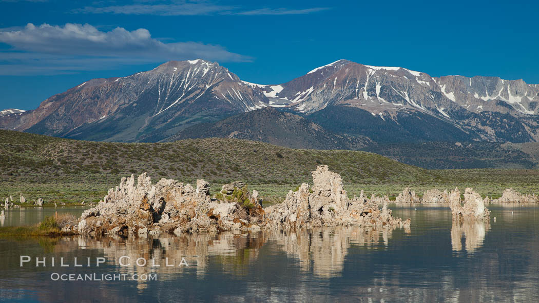 Tufa towers rise from Mono Lake, with the Eastern Sierra visible in the distance. Tufa towers are formed when underwater springs rich in calcium mix with lakewater rich in carbonates, forming calcium carbonate (limestone) structures below the surface of the lake. The towers were eventually revealed when the water level in the lake was lowered starting in 1941. California, USA, natural history stock photograph, photo id 26992