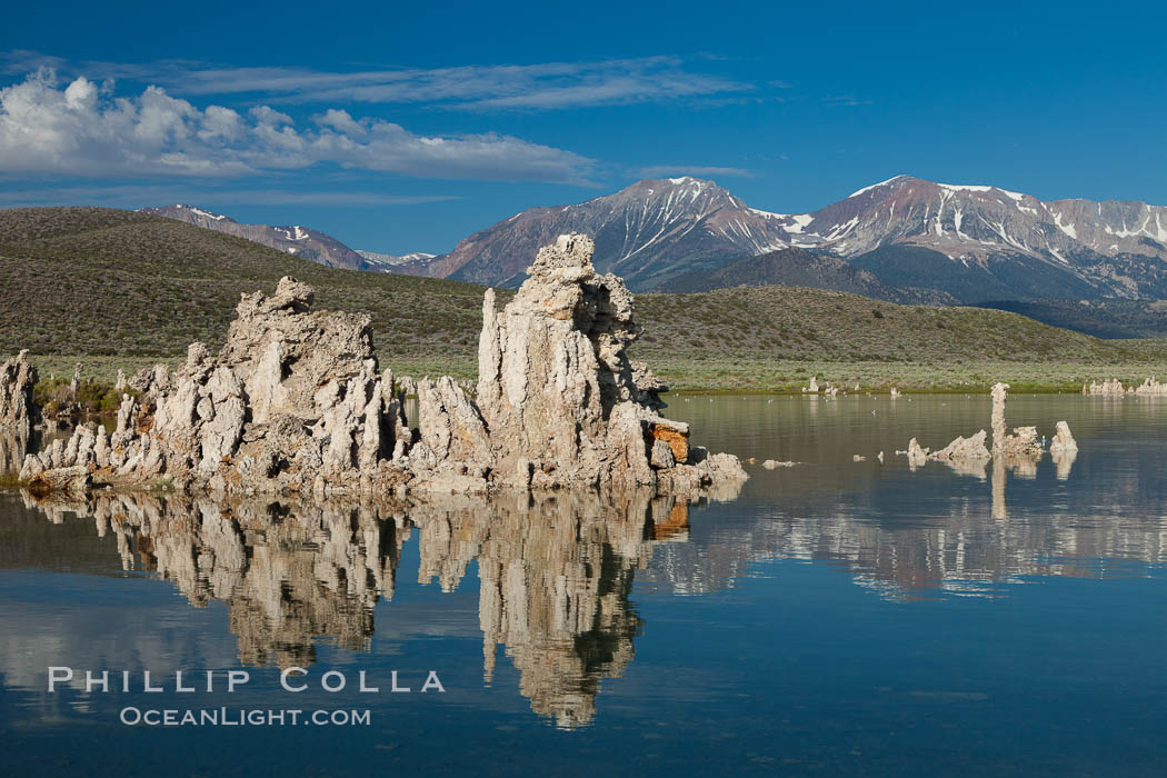 Tufa towers rise from Mono Lake, with the Eastern Sierra visible in the distance. Tufa towers are formed when underwater springs rich in calcium mix with lakewater rich in carbonates, forming calcium carbonate (limestone) structures below the surface of the lake. The towers were eventually revealed when the water level in the lake was lowered starting in 1941. California, USA, natural history stock photograph, photo id 26991