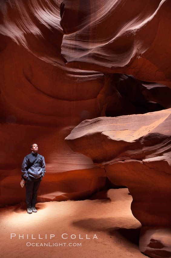 A hiker admiring the striated walls and dramatic light within Antelope Canyon, a deep narrow slot canyon formed by water and wind erosion. Navajo Tribal Lands, Page, Arizona, USA, natural history stock photograph, photo id 18008
