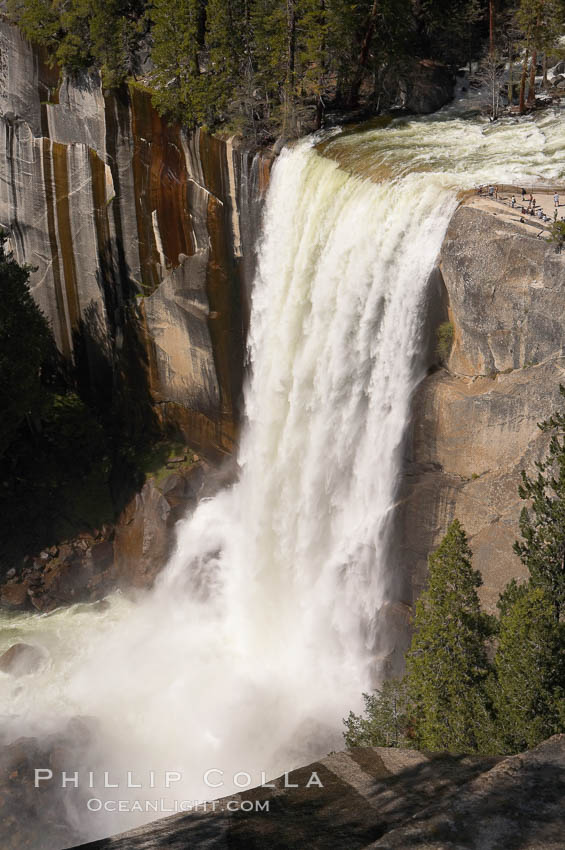Vernal Falls at peak flow in late spring.  Hikers are visible at the precipice of the waterfall.  Viewed from the John Muir Trail.  Vernal Falls drops 317 through a joint in the narrow Little Yosemite Valley. Yosemite National Park, California, USA, natural history stock photograph, photo id 16112