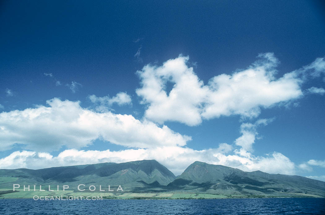 West Maui mountains rise above the coast of Maui, with clouds flanking the ancient eroded remnants of a volcano. Hawaii, USA, natural history stock photograph, photo id 05606