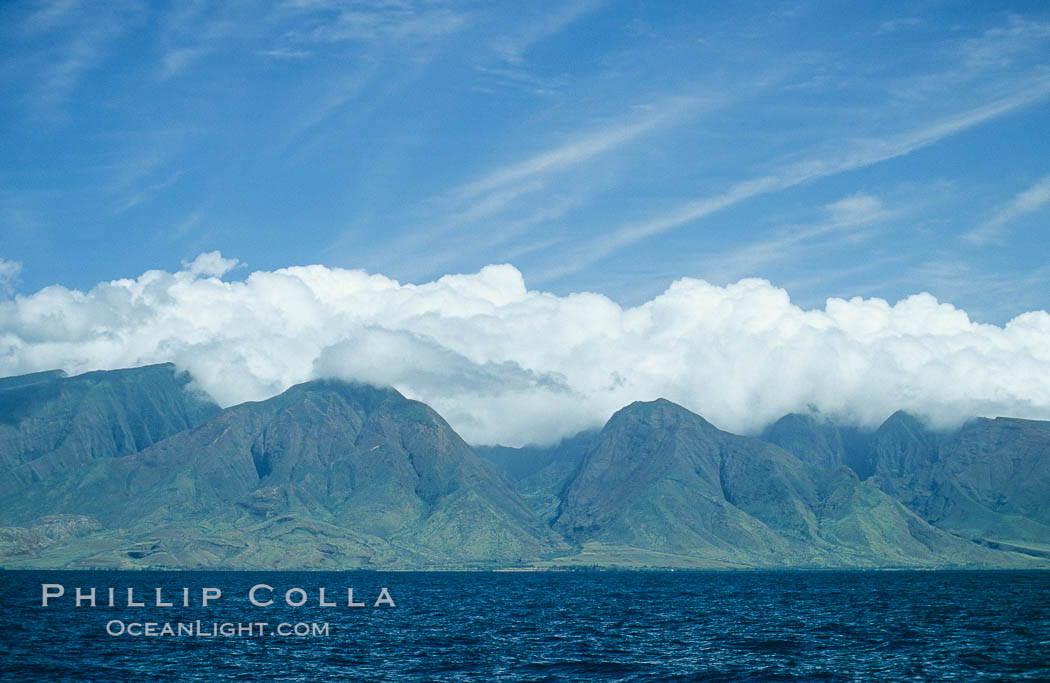 West Maui mountains rise above the coast of Maui, with clouds flanking the ancient eroded remnants of a volcano. Hawaii, USA, natural history stock photograph, photo id 05858