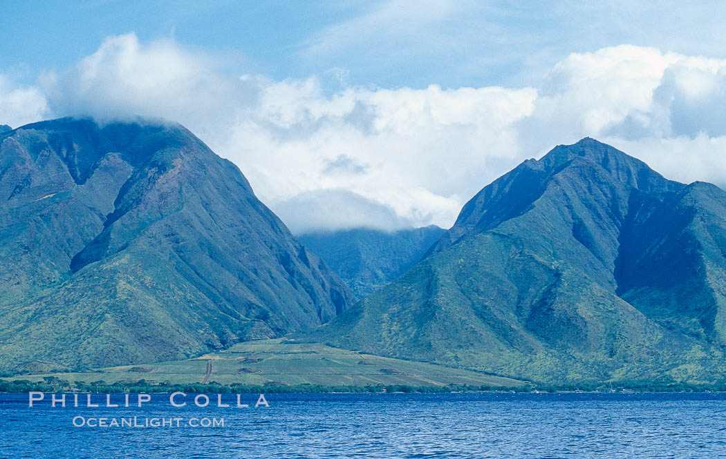 West Maui mountains rise above the coast of Maui, with clouds flanking the ancient eroded remnants of a volcano. Hawaii, USA, natural history stock photograph, photo id 05856