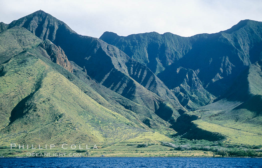 West Maui mountains rise above the coast of Maui, with clouds flanking the ancient eroded remnants of a volcano. Hawaii, USA, natural history stock photograph, photo id 05864