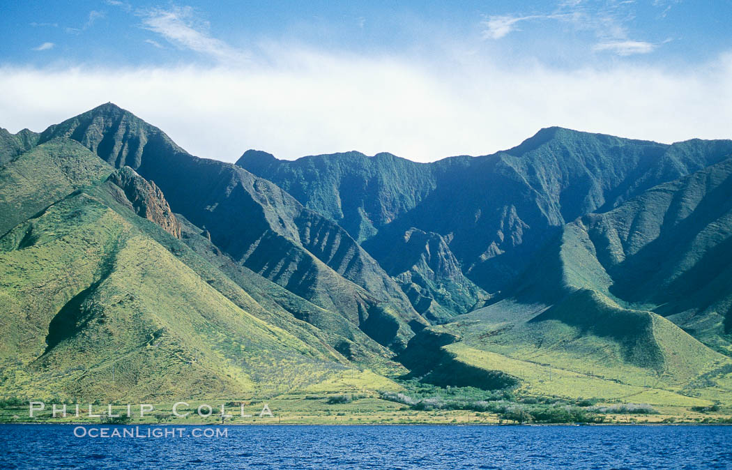 West Maui mountains rise above the coast of Maui, with clouds flanking the ancient eroded remnants of a volcano. Hawaii, USA, natural history stock photograph, photo id 05863