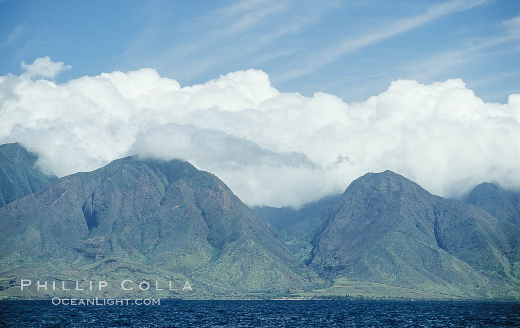West Maui mountains rise above the coast of Maui, with clouds flanking the ancient eroded remnants of a volcano. Hawaii, USA, natural history stock photograph, photo id 05857