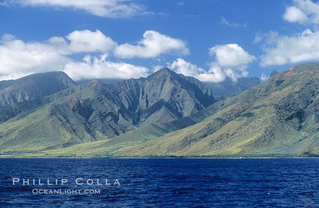 West Maui mountains rise above the coast of Maui, with clouds flanking the ancient eroded remnants of a volcano. Hawaii, USA, natural history stock photograph, photo id 05865