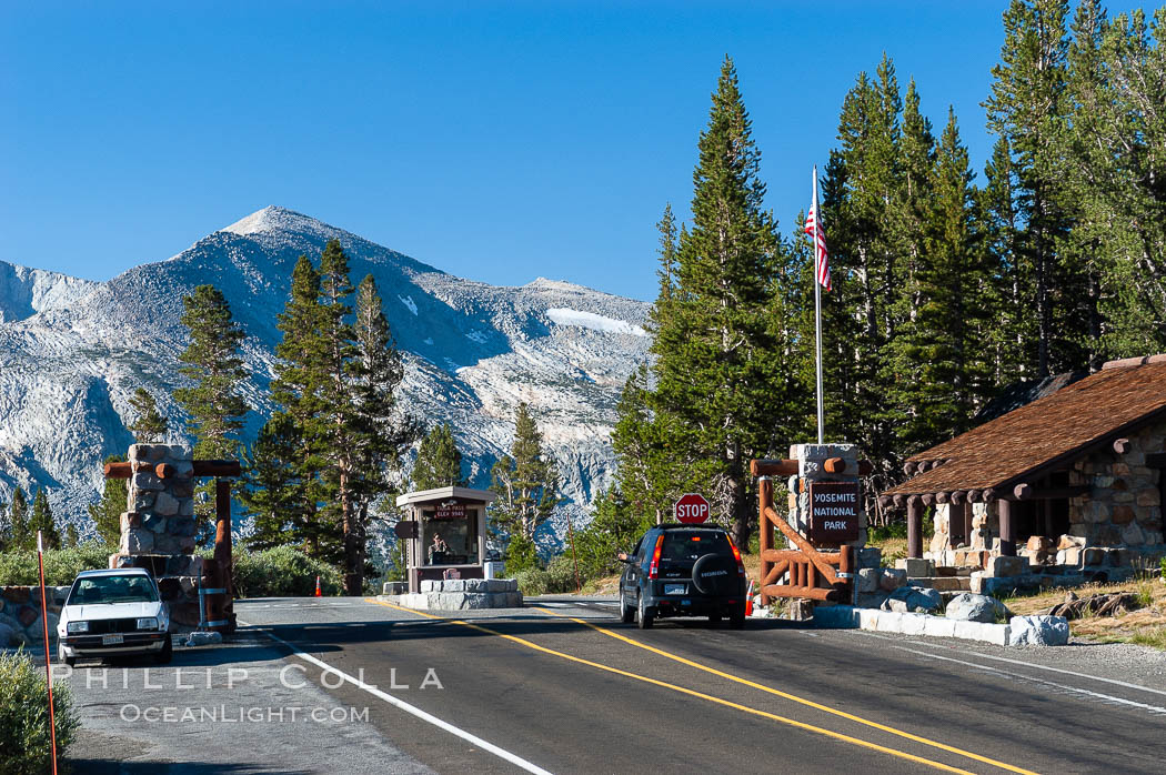 A car enters the stunning High Sierra entrance to Yosemite National Park at the summit of Tioga Pass. Mammoth Peak is seen in the background. A lucky park ranger, whose office is perhaps more beautiful than any other in the world, greets each car as it passes through. Tuolumne Meadows area of Yosemite National Park. California, USA, natural history stock photograph, photo id 09978