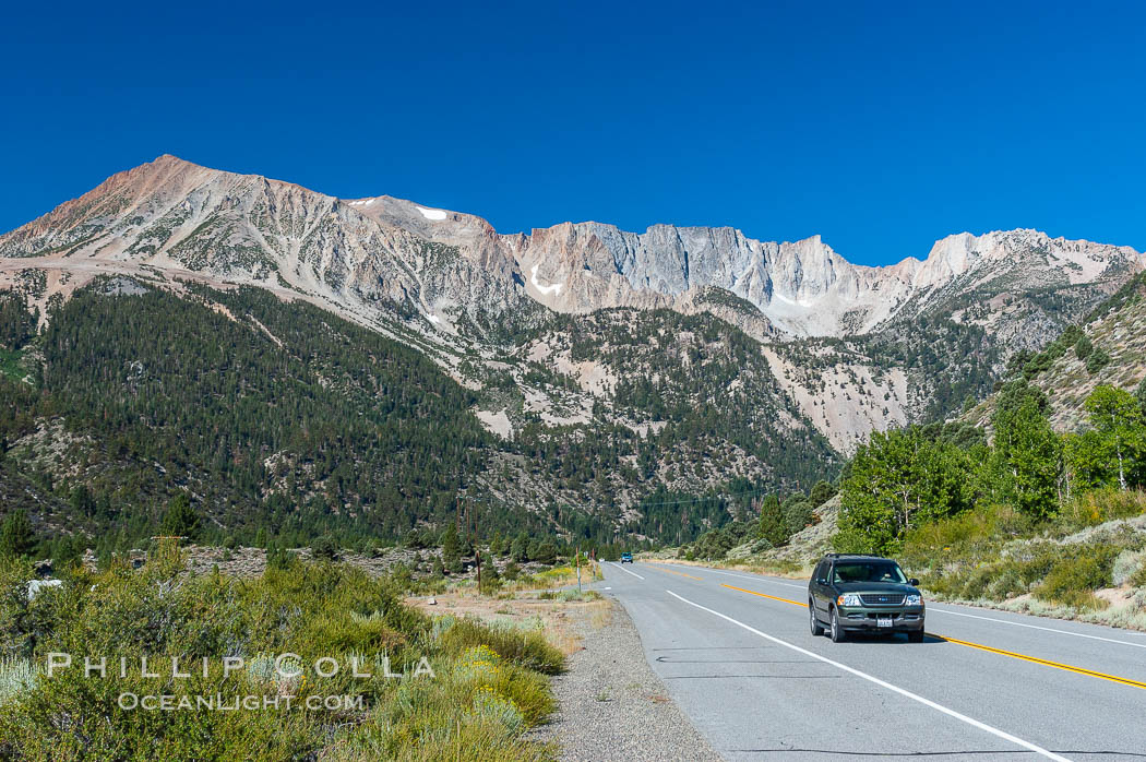 A car passes below stunning High Sierra peaks and mountains as it travels eastward on the Tioga Pass road from Yosemite to the town of Lee Vining. California. Yosemite National Park, USA, natural history stock photograph, photo id 09977