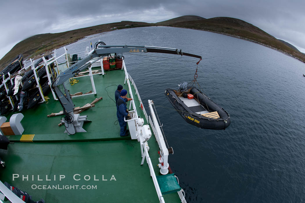 Zodiac boats, are lowered into the ocean from the ship M/V Polar Star in preparation for a day exploring New Island in the Falklands. Falkland Islands, United Kingdom, natural history stock photograph, photo id 23708